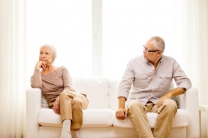 senior couple sitting on sofa at home